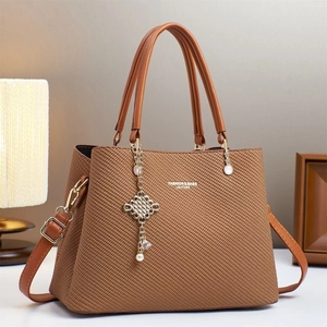 Sac fourre-tout en cuir marron tressé avec logo doré et pendentif perle élégant