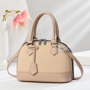 Minimalist macaron shell bag with beige woven texture and premium leather stitching