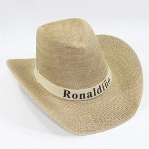Detalle de sombrero vaquero de paja café claro con cinta impresa de Ronaldinho