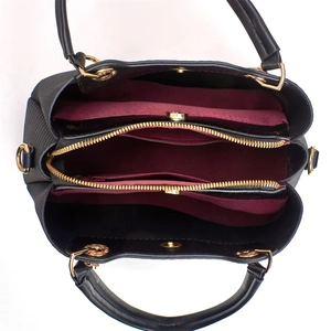 Innenansicht der schwarzen Tasche mit drei Fächern und weinrotem Textilfutter