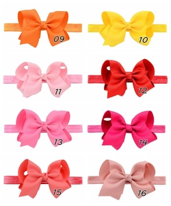 Detail showing 8 colors of handmade elastic baby headbands with grosgrain ribbon bows