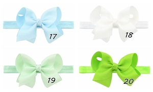 Detail of high-elasticity baby headbands featuring large textured grosgrain hair bows