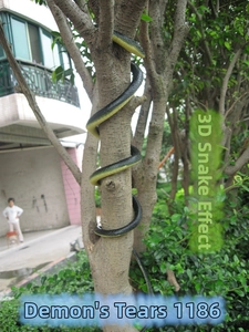 Dettaglio di un serpente giocattolo realistico in gomma con texture a scaglie su ramo