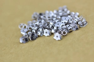 Close-up of 925 sterling silver butterfly earring backs with engraved purity marks