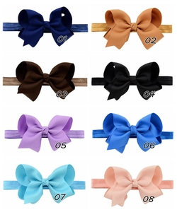 Detailed close-up of eight colorful handmade grosgrain bow headbands for babies