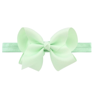 Détail du nœud en gros-grain vert menthe et du bandeau élastique assorti pour enfants