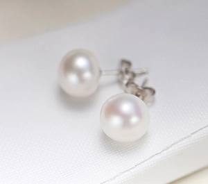 Macro shot of 925 sterling silver pearl stud earrings with polished finish and backings