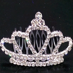 Detail view of heart-shaped crown hair comb with sparkling rhinestones on black background