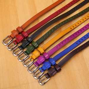 Detail of colorful leather belts featuring heart-shaped cutouts and silver pin buckles