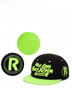 Detail view of 3D embroidery and stitching on black and neon green hip hop flat brim cap