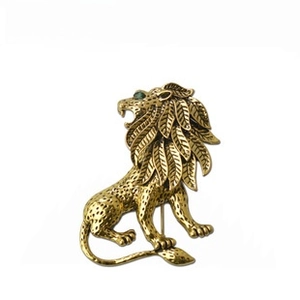 Vintage gold-plated lion brooch with leaf mane and green eyes for men and women apparel.