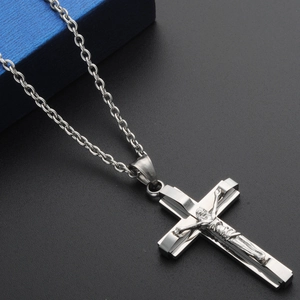 Macro shot of silver titanium steel cross pendant with Jesus crucifix detail on link chain