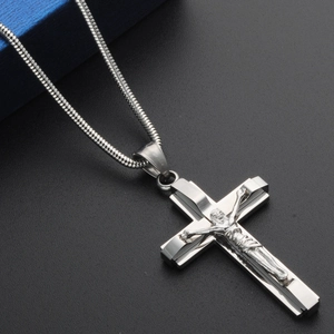 Detailed view of silver stainless steel crucifix pendant on a sleek snake chain