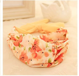 Close-up of floral headband with pink and orange patterns on soft textured fabric