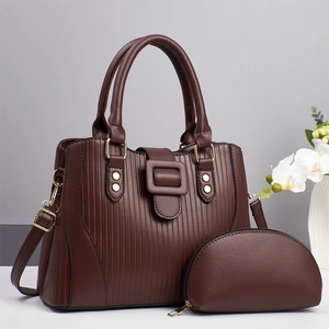 Detail of dark brown striped tote bag and small pouch with gold studs and shoulder strap