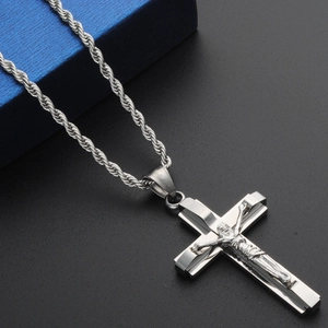 Close-up of a silver stainless steel crucifix pendant on a twisted rope chain necklace