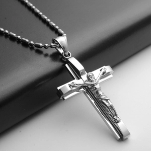 Detailed close-up of a silver stainless steel crucifix pendant with beads on a black background