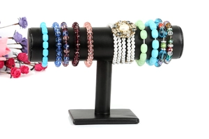 Detail of colorful beaded bracelets and faux pearl jewelry on black T-bar display stand