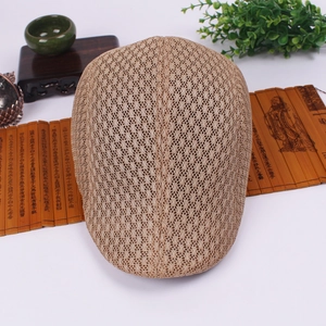 Close-up of beige mesh newsboy hat featuring breathable texture on rustic decor