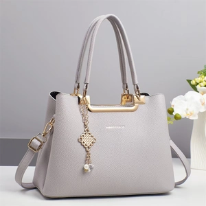 Schicke Handtasche in Grau mit Litschimuster, Goldbeschlägen und Perlen-Quasten-Anhänger