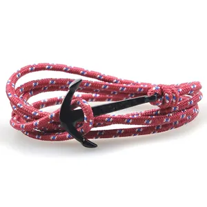 Macro detail of nautical tricolor braided rope bracelet with black anchor metal clasp