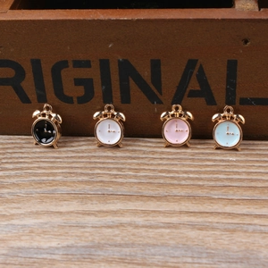 Detail showing four colorful enamel alarm clock charms for DIY jewelry making