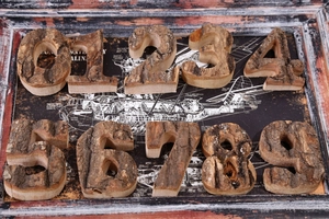 Detail of natural birch wood numbers 0-9 with rustic bark texture on a blueprint background