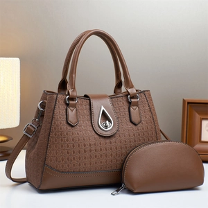 Detail of a brown woven texture leather handbag set with silver teardrop metal twist lock