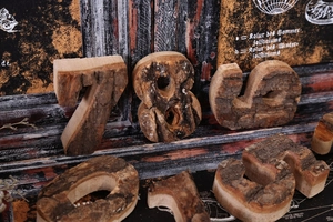 Close-up of vintage style natural wood numbers with bark edges for rustic cafe decor