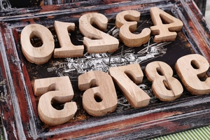 Macro shot of 0-9 vintage solid wood numbers with natural grain on a retro background