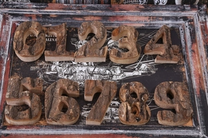 Flat lay of vintage wooden numbers 0-9 with rustic bark texture on mechanical drawings