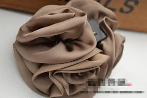 Detailed view of large mocha satin rose hair clip with elegant layered fabric petals