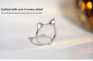 Macro shot showing minimalist silver cat-ear ring design with polished smooth surface