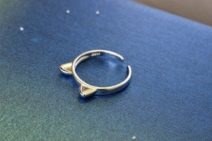 Macro shot of S925 sterling silver cat ear ring with engraved S925 hallmark on blue surface