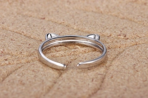 Close-up of minimalist cat ear ring with adjustable open design and polished silver finish