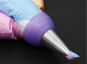 Close-up of a three-color cream piping bag with purple coupler and stainless steel nozzle