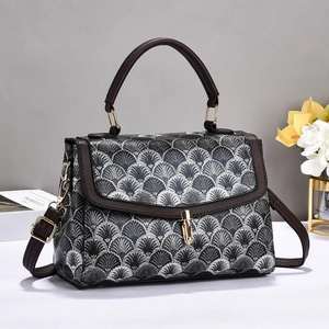 Fashionable tote bag with feather print pattern, leather trim and gold metal lock clasp