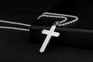 Detailed view of a silver stainless steel cross pendant necklace with a twisted rope chain