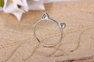 Macro detail of silver adjustable cat ear ring on a natural brown textured background