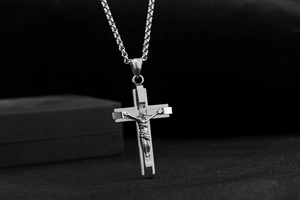 Detailed close-up of a silver stainless steel crucifix pendant with 3D Jesus relief