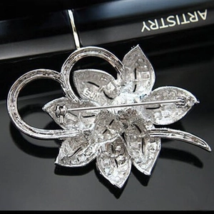 Macro detail of silver flower brooch back showing sturdy pin clasp and sun hallmark