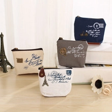 Close-up of vintage canvas coin purses with Eiffel Tower prints on a rustic wooden desk