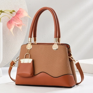 Brown woven texture handbag with gold hardware, adjustable strap and mini charm