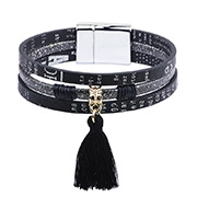 Detail of leather wrap bracelet featuring a golden mask charm and magnetic clasp