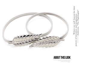Detailed view of silver elastic chain belt featuring leaf buckle and metal spring texture