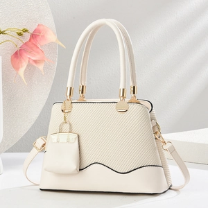 Elegant cream beige woven handbag with gold hardware and stylish mini bag charm