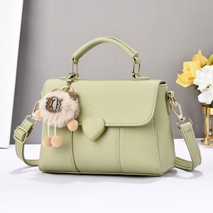 Détail du sac bandoulière vert sauge avec boucle coeur dorée et breloque mouton