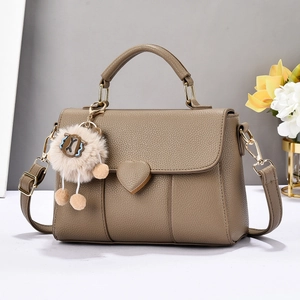 Détail du sac à main en cuir grainé kaki avec fermoir cœur et breloque en peluche