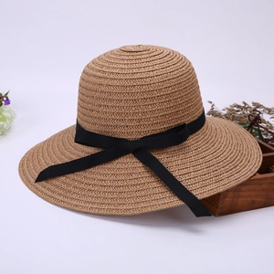 Detailed close-up of straw sun hat featuring a fine weave and elegant black ribbon bow