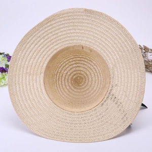 Detail of a wide brim straw sun hat featuring fine weaving and sweatband for beach trips